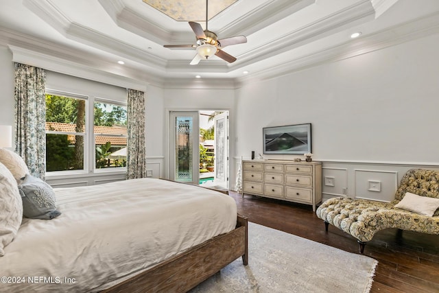 bedroom with dark hardwood / wood-style floors, ornamental molding, access to exterior, ceiling fan, and a tray ceiling