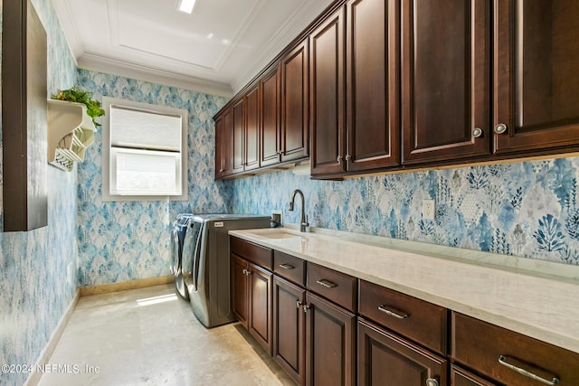 washroom with crown molding, cabinets, washer and clothes dryer, and sink