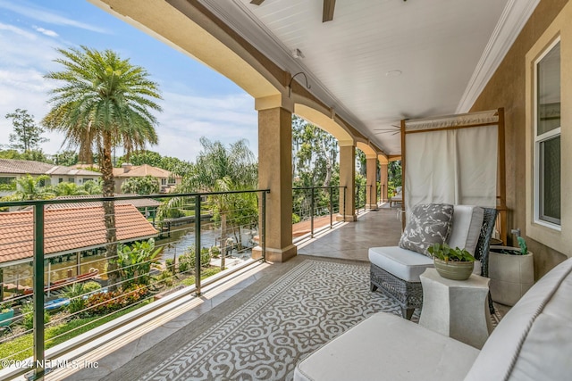 balcony with a water view and ceiling fan