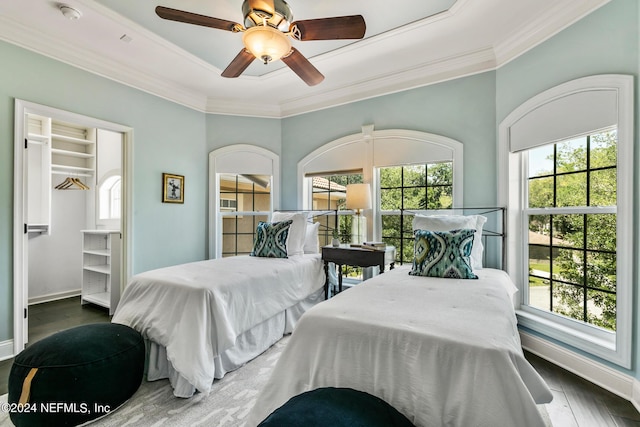 bedroom featuring dark wood-type flooring, ornamental molding, and multiple windows