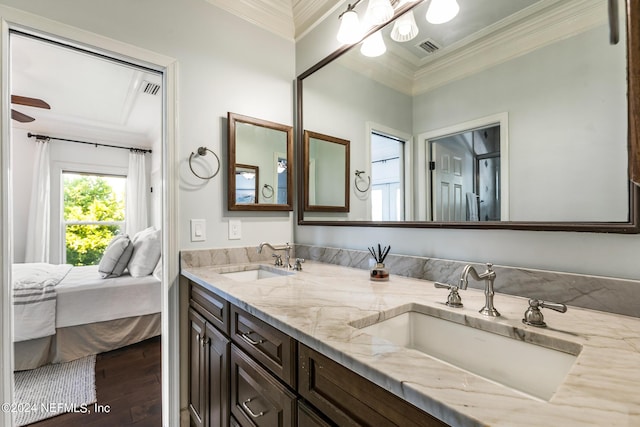 bathroom with crown molding, wood-type flooring, and vanity