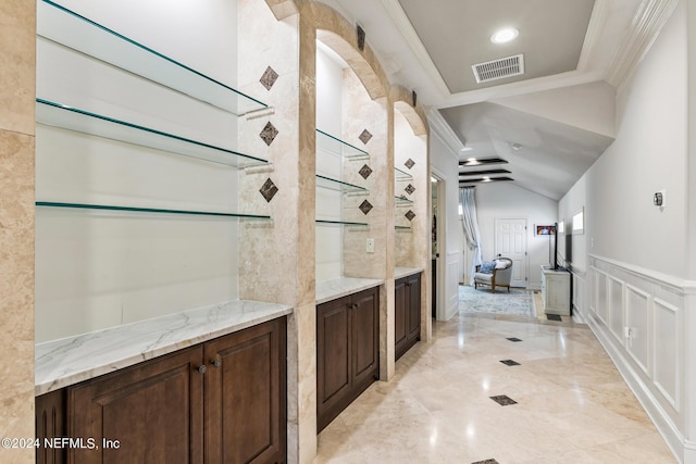 bathroom with ornamental molding and vaulted ceiling