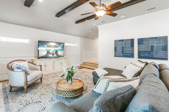 living room with ceiling fan, light hardwood / wood-style floors, and vaulted ceiling with beams