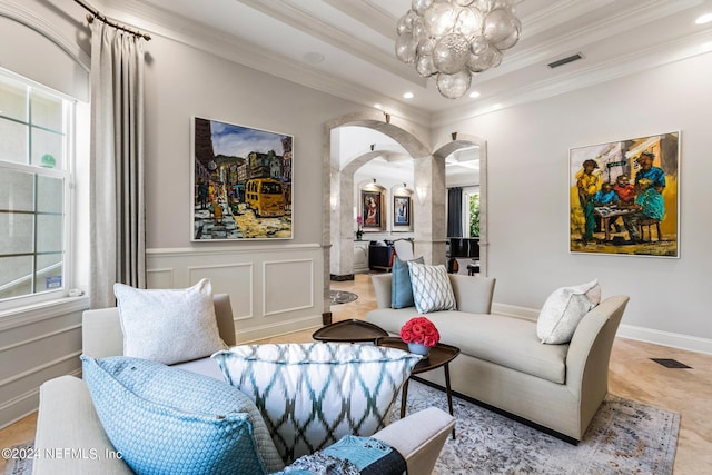 living room featuring ornamental molding, an inviting chandelier, and a tray ceiling