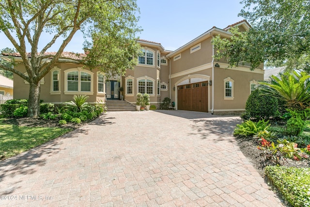 mediterranean / spanish home featuring a garage