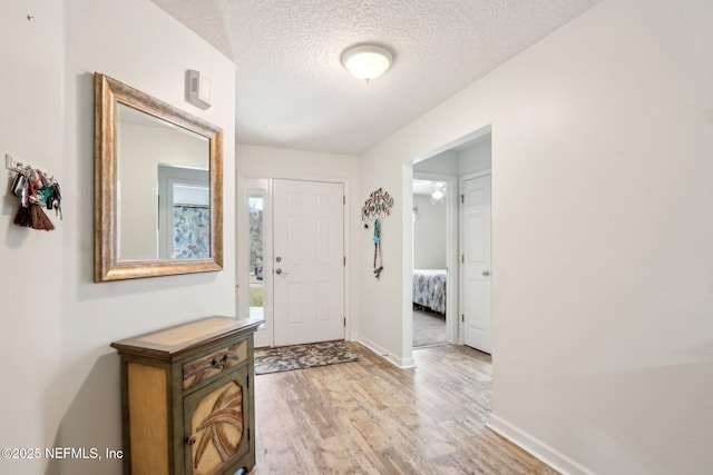 entryway with light hardwood / wood-style flooring and a textured ceiling