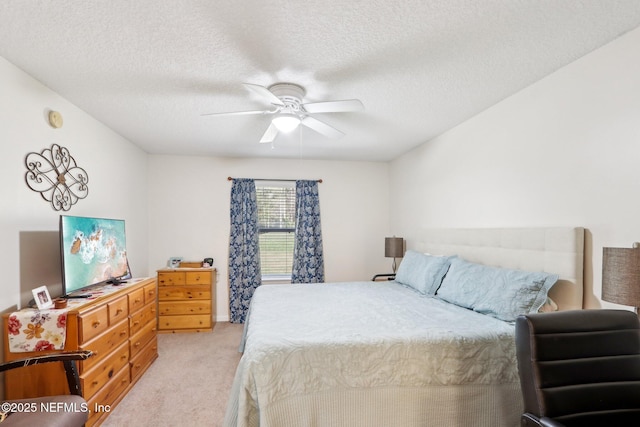 carpeted bedroom with ceiling fan and a textured ceiling