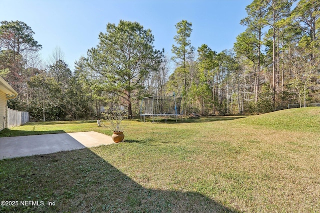 view of yard with a trampoline and a patio area