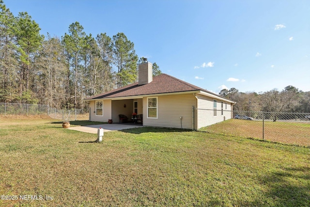 back of house with a lawn and a patio