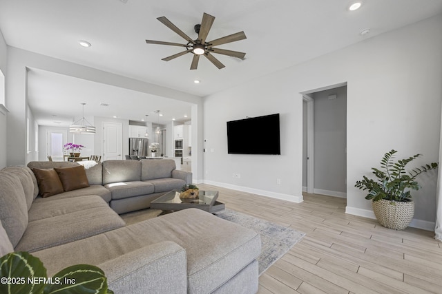 living room featuring ceiling fan and light hardwood / wood-style floors