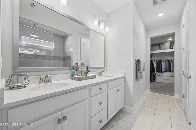 bathroom featuring tile patterned floors, vanity, and a tile shower