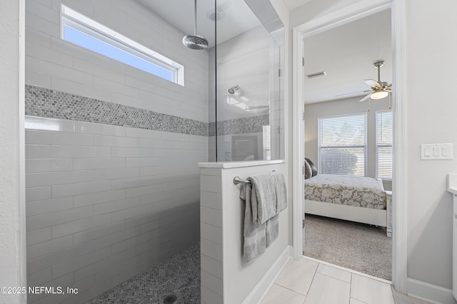 bathroom with a tile shower, a wealth of natural light, and ceiling fan