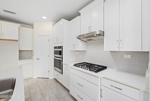 kitchen featuring under cabinet range hood, visible vents, white cabinets, and stainless steel appliances