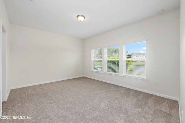 carpeted spare room with baseboards