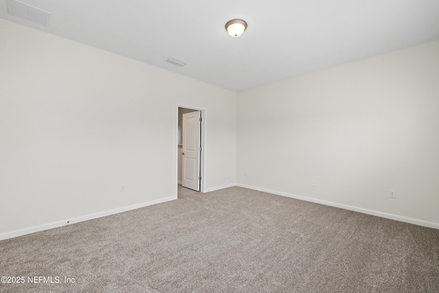 unfurnished room featuring baseboards, visible vents, and light carpet