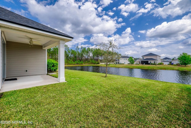 view of yard with a water view and a patio