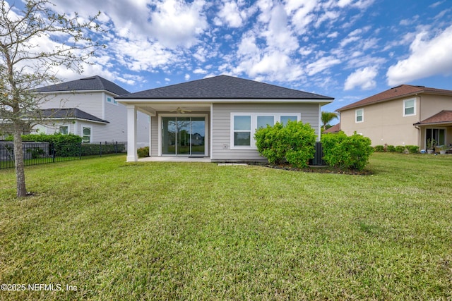 rear view of house with a patio, a yard, and fence