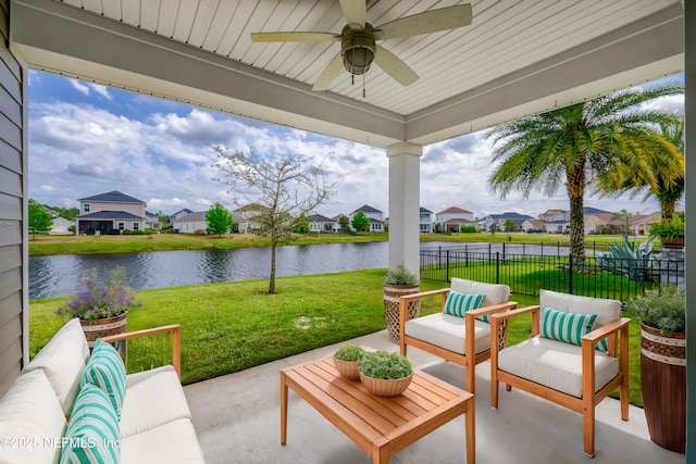 view of patio with a residential view, fence, ceiling fan, and a water view