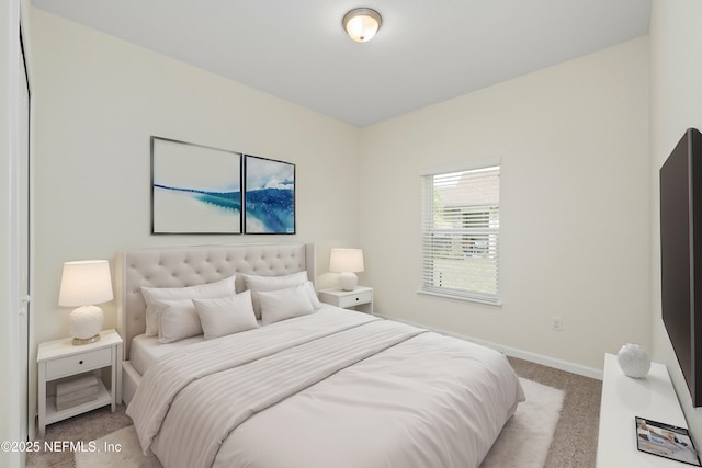 bedroom featuring baseboards and light carpet