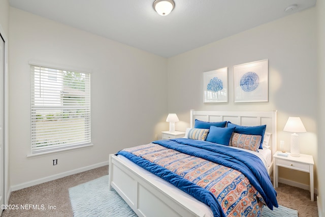 bedroom featuring light colored carpet and baseboards