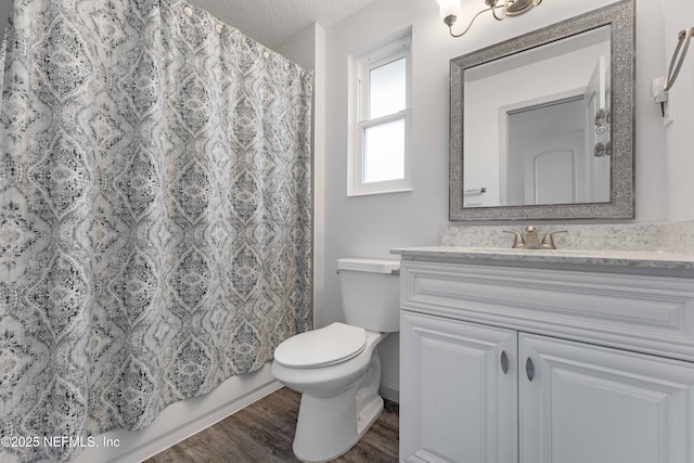 bathroom with vanity, toilet, hardwood / wood-style floors, and a textured ceiling