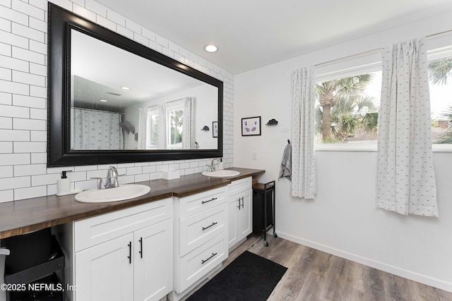 bathroom with hardwood / wood-style flooring, vanity, a shower with shower curtain, and backsplash