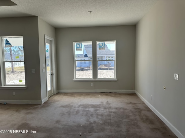 interior space with carpet, a textured ceiling, and baseboards