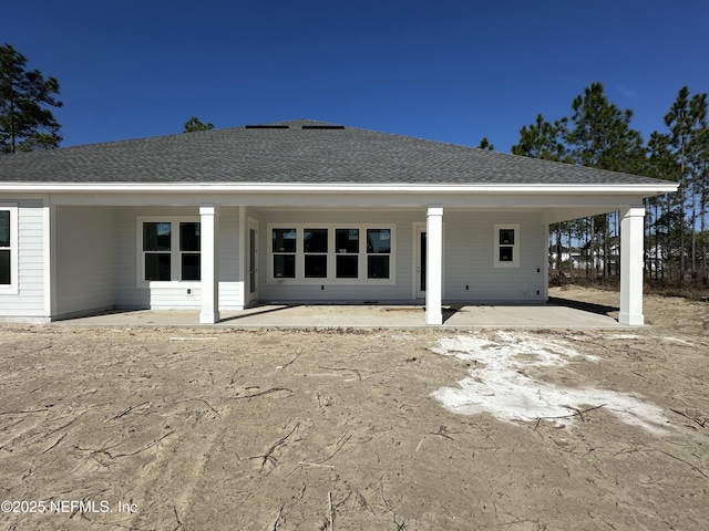 back of property featuring a patio and roof with shingles