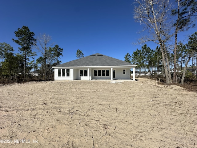 back of property with roof with shingles