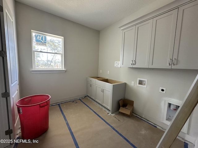 laundry room with a textured ceiling, cabinet space, hookup for a washing machine, and electric dryer hookup