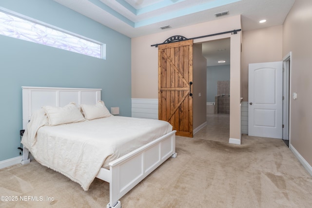 carpeted bedroom featuring a barn door