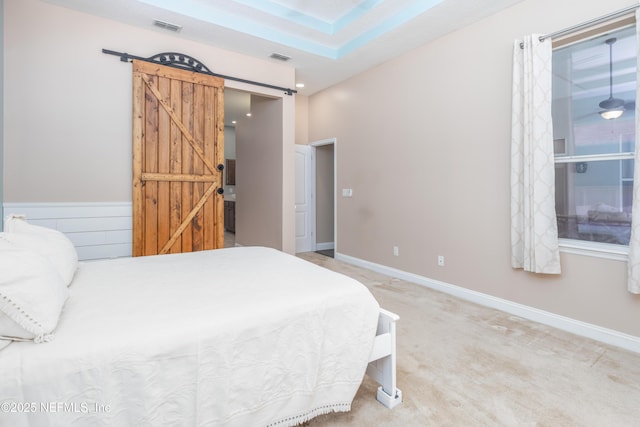 carpeted bedroom featuring a barn door