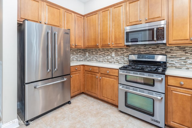 kitchen with tasteful backsplash, appliances with stainless steel finishes, and light tile patterned floors