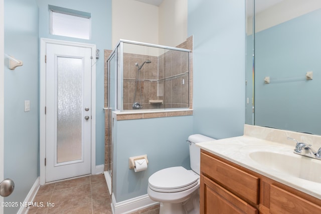 bathroom with a shower with door, vanity, tile patterned flooring, and toilet