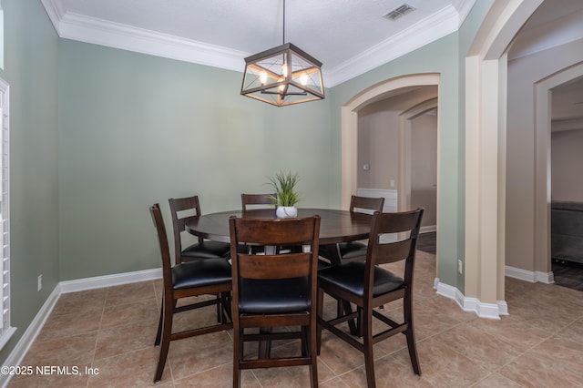 tiled dining space featuring ornamental molding and a notable chandelier