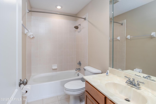 full bathroom featuring tiled shower / bath, vanity, toilet, tile patterned floors, and a textured ceiling