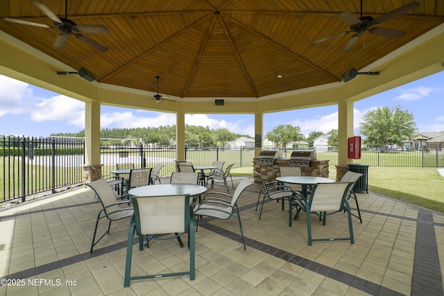 view of patio / terrace featuring a gazebo, a water view, exterior kitchen, and ceiling fan