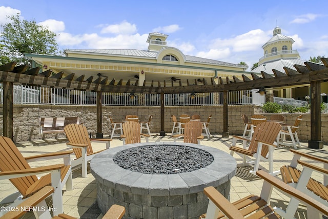 view of patio / terrace with a pergola, ceiling fan, and a fire pit