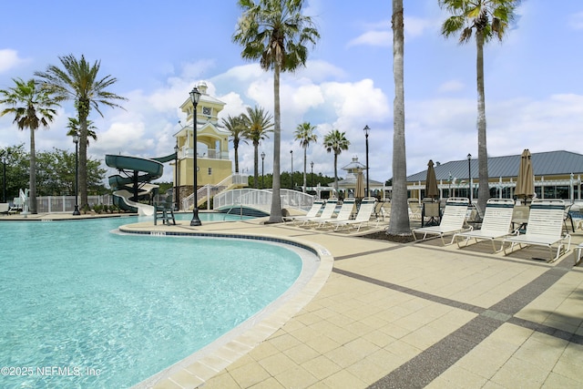 view of swimming pool with a patio and a water slide