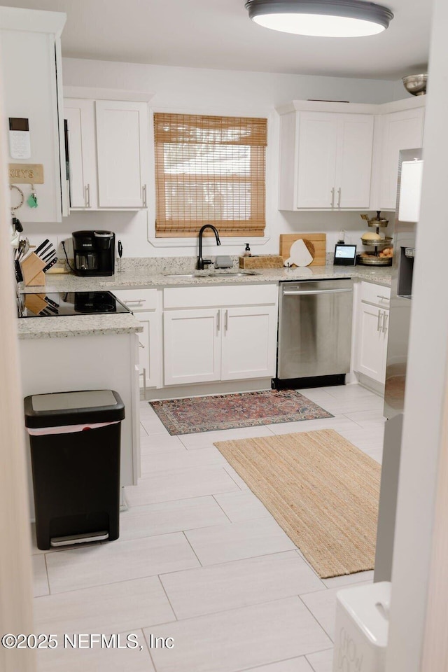 kitchen with dishwasher, sink, white cabinets, black electric stovetop, and light stone countertops