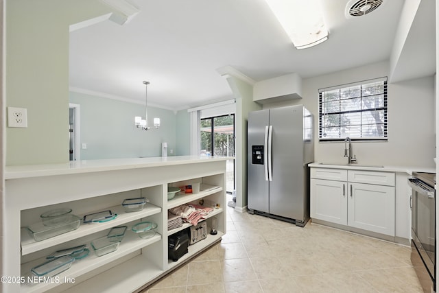 kitchen featuring hanging light fixtures, sink, appliances with stainless steel finishes, white cabinets, and crown molding