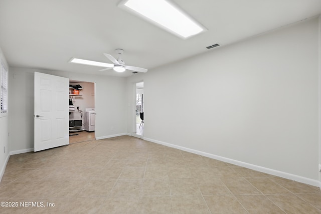tiled empty room with ceiling fan and independent washer and dryer