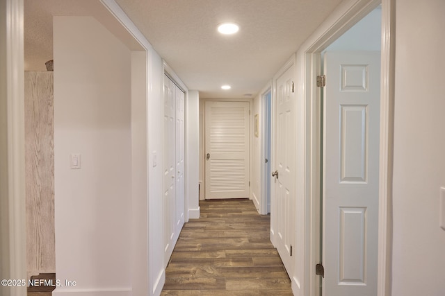 hallway featuring dark hardwood / wood-style floors and a textured ceiling