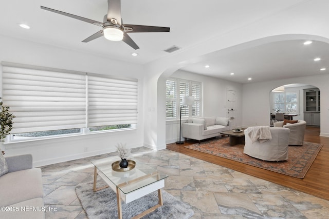 living room featuring a healthy amount of sunlight and ceiling fan