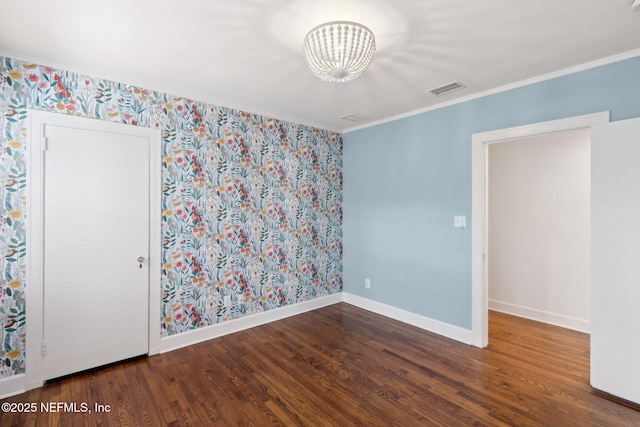 empty room with ornamental molding and dark hardwood / wood-style floors