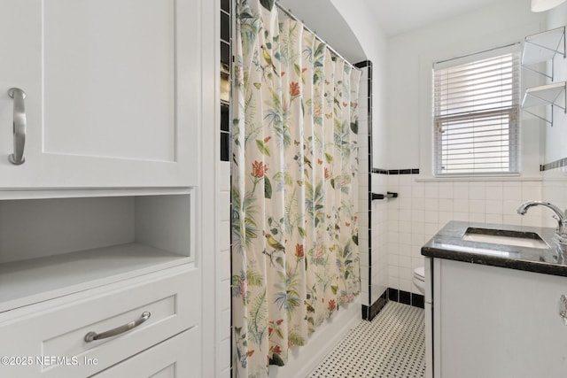 full bathroom with vanity, tile walls, shower / bathtub combination with curtain, and toilet