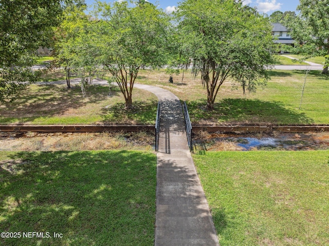 view of property's community featuring a water view and a yard