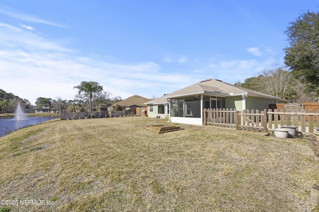 back of property with a sunroom and a lawn