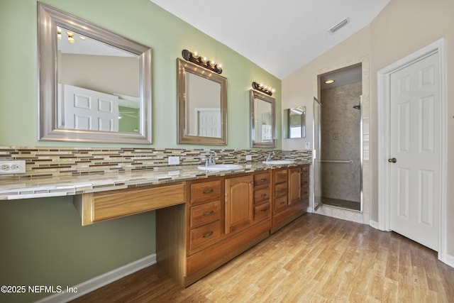 bathroom featuring hardwood / wood-style flooring, backsplash, an enclosed shower, vanity, and vaulted ceiling