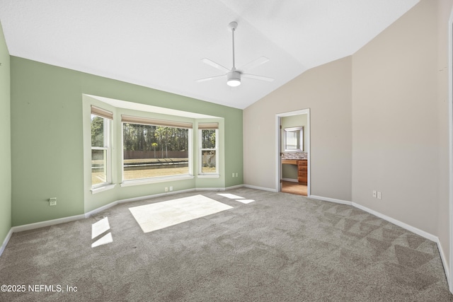 unfurnished bedroom featuring vaulted ceiling, carpet, connected bathroom, and ceiling fan